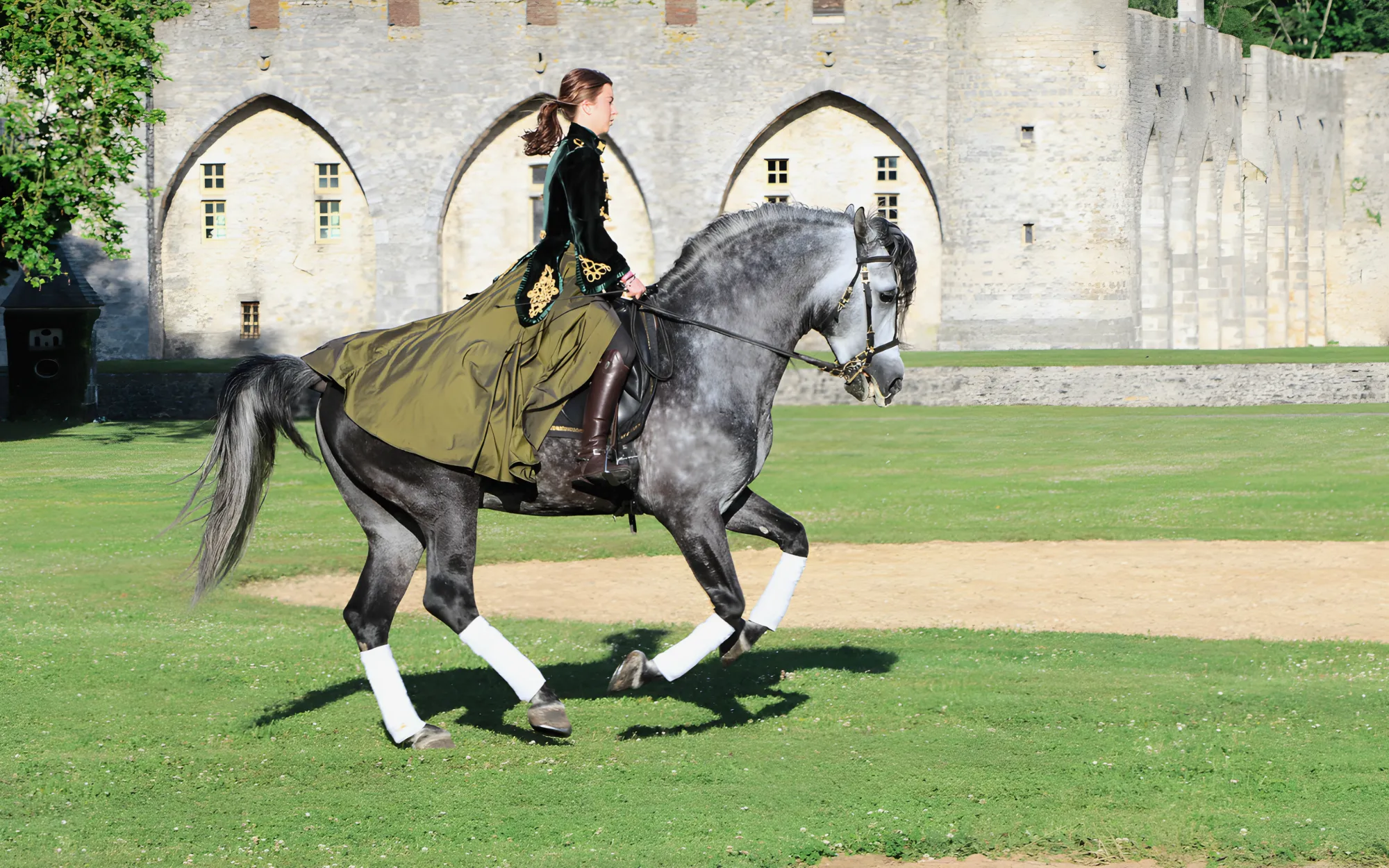 A rider in dressage before the arcades of the curtain wall
