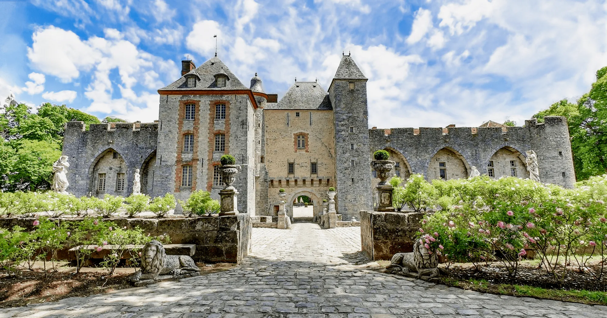 The château front from the rose garden, stone lions in the foreground