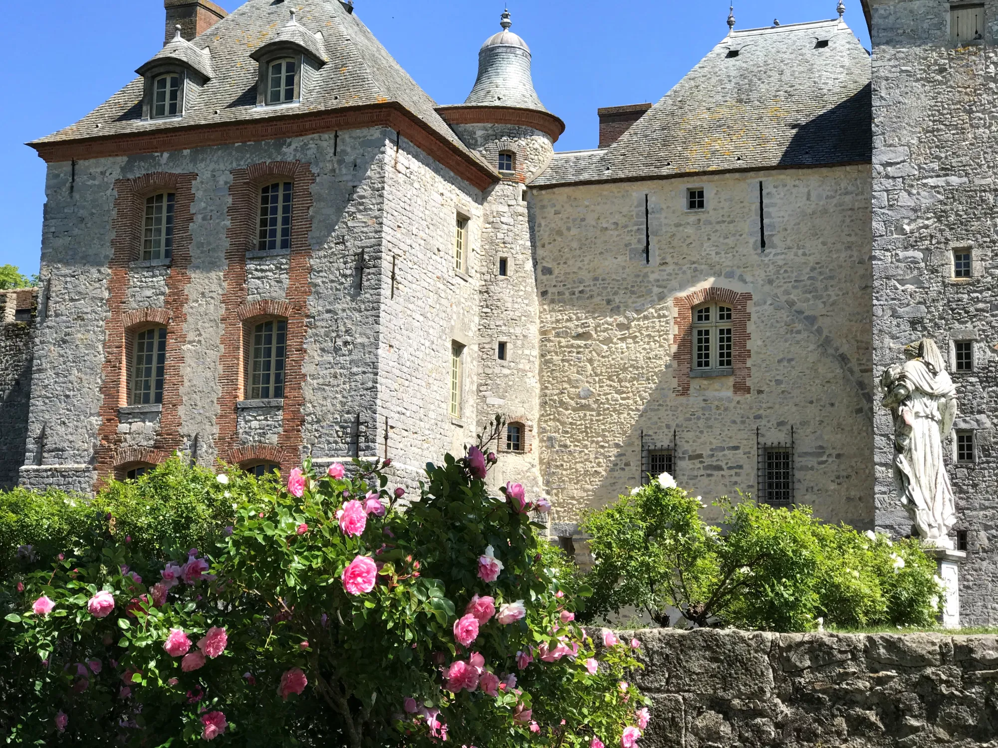 The north façade and its turrets above a bank of roses