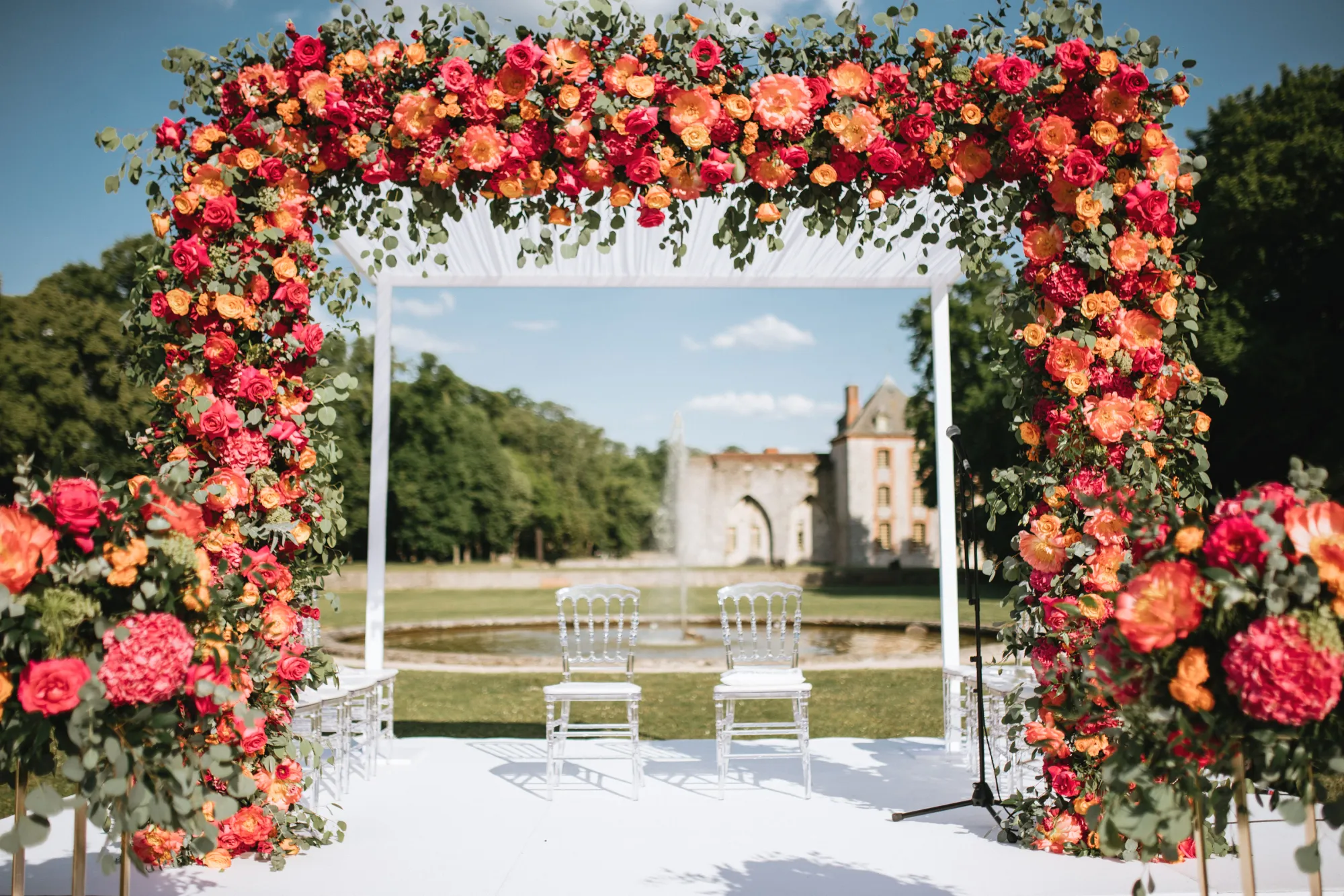 A floral arch on the lawn, the château behind