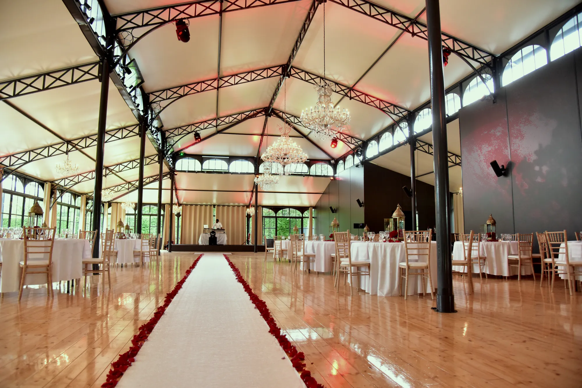 The Orangerie set for dinner, a red aisle and round tables