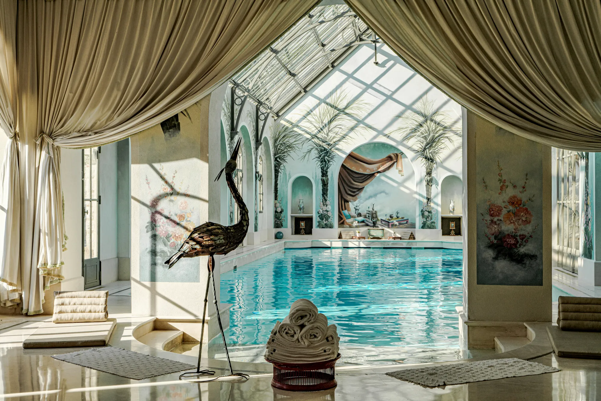 The pool under its glass roof, palm frescoes