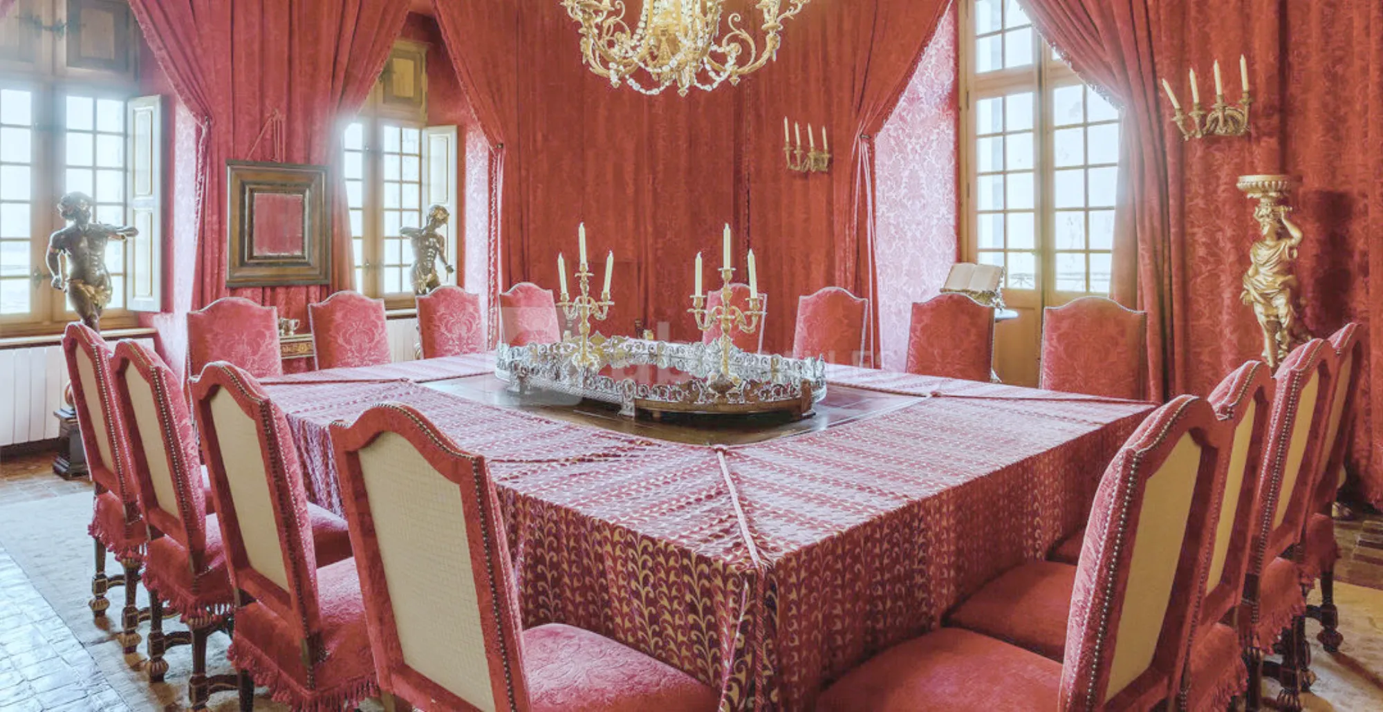 The Salon Rouge set for dinner, red walls and red chairs