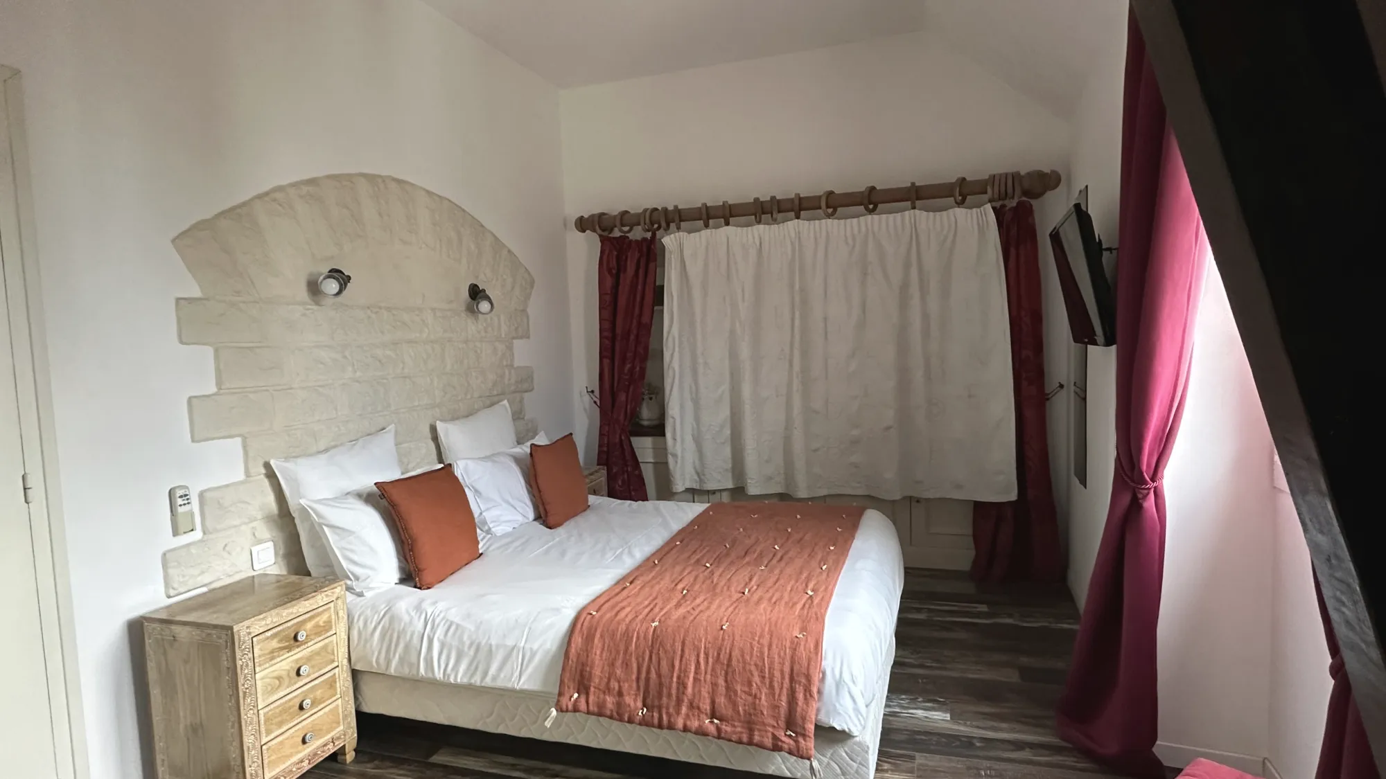 A bedroom of the gîte, a stone headboard, a rust throw